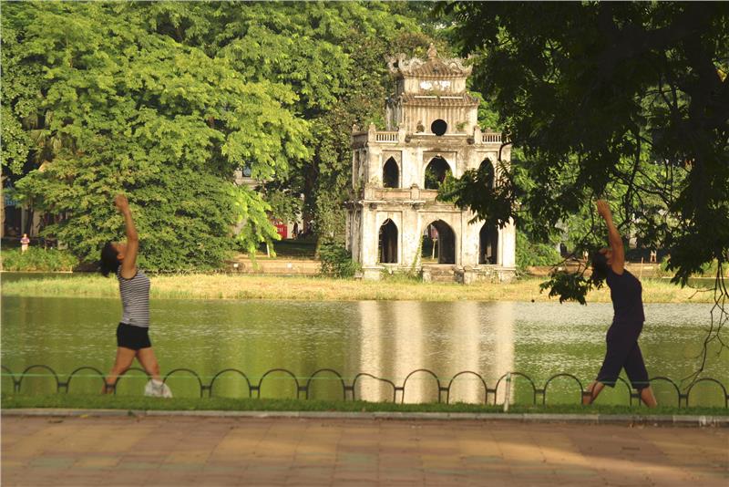 Local people do exercises around Hoan Kiem Lake